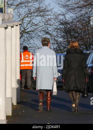 Britische Straßenszene, Menschen auf dem Straßenbelag britischer Postbote Royal Mail, der auf der Lieferung herumläuft. Stockfoto