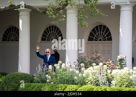 Washington, DC, USA. 21.. Juni 2022. US-Präsident Joe Biden winkt aus dem Rosengarten zu drücken, nachdem er am Dienstag, den 21. Juni, eine Covid-19-Impfklinik in Washington, DC, USA, besucht hatte. 2022. Säuglinge und Kleinkinder in den USA können jetzt gegen Covid-19 geimpft werden, nachdem die Schüsse von Moderna und Pfizer am Samstag die Unterstützung der Gesundheitsberater gewonnen haben. Quelle: Sarah Silbiger/Pool via CNP/dpa/Alamy Live News Stockfoto