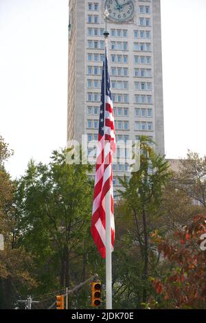 Manhattan, New York, USA - November 11. 2019: US-Flagge im Madison Square Park mit Skyscraper im Hintergrund in NYC Stockfoto