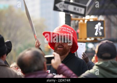 Manhattan, New York, USA - November 11. 2019: Männer tragen einen großen Make America Great Again Hut in NYC während der Veterans Day Parade. Übergroße MAGA-Mütze, rot Stockfoto