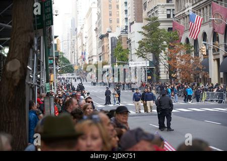 Manhattan, New York, USA - November 11. 2019: Fifth Avenue vor der Veterans Day Parade in NYC. Leute auf dem Bürgersteig, die darauf warten, dass die Parade beginnt, Polic Stockfoto