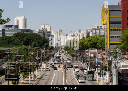 Starker Verkehr, der an einem normalen Arbeitstag an beiden Wegen der Francisco Matarazzo Avenue vorbeifährt, mit vielen Wolkenkratzern im Hintergrund unter sonnigem blauen Himmel. Stockfoto