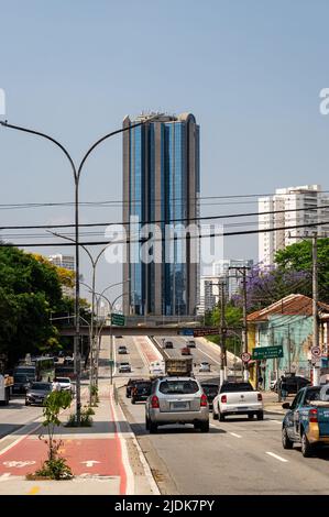 Starker Geschäftsverkehr, der an der Antarktis Avenue mit dem Memorial Office-Gebäude weit in der Mitte unter sonnenklarem, blauem Himmel vorbeifährt. Stockfoto