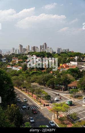 Fernes Stadtbild von Sumare aus betrachtet, mit Blick auf die Viertel Pacaembu und Perdizes und der Paulo VI Avenue unter wolkendem, sonnigen blauen Himmel. Stockfoto