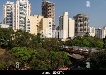 Stadtansicht des Pinheiros-Viertels mit vielen Arten von Wohn- und Handelstürmen mit viel grüner Vegetation unter sonnigem blauen Himmel. Stockfoto