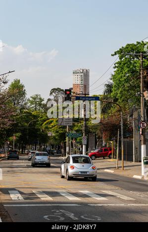 Geschäftsverkehr, der an der Ampelkreuzung der Sumare Avenue in der Nähe der Kreuzung mit der Straße Irmaos Karmann unter sonnenklarem, blauem Himmel vorbeigeht. Stockfoto