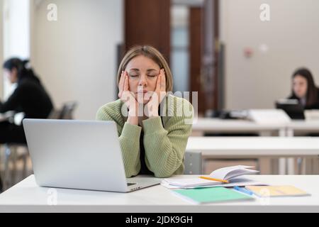 Erschöpfte müde Studentin mittleren Alters, die während des Studiums in der Erwachsenenbildungsklasse einschläft Stockfoto