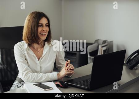 Porträt einer fröhlichen jungen Frau, die im Büro arbeitet, Buchhalterin bei der Arbeit Stockfoto