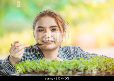 Mädchen jung teen wachsenden Pflanzenbaum im Garten niedlich schön Stockfoto