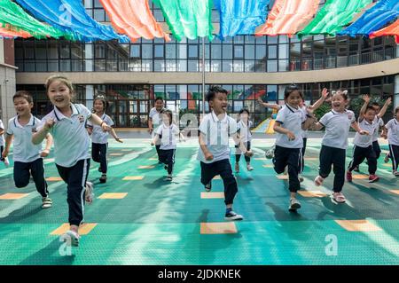 YANTAI, CHINA - 23. JUNI 2022 - Kinder laufen auf einem Spielplatz in einem experimentellen Kindergarten im Bezirk Penglai in Yantai, dem ostchinesischen Shandong Prov Stockfoto