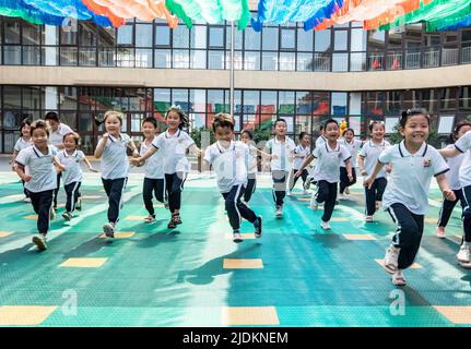 YANTAI, CHINA - 23. JUNI 2022 - Kinder laufen auf einem Spielplatz in einem experimentellen Kindergarten im Bezirk Penglai in Yantai, dem ostchinesischen Shandong Prov Stockfoto