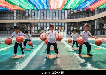 YANTAI, CHINA - 23. JUNI 2022 - Kinder haben ein Basketballspiel auf dem Spielplatz eines experimentellen Kindergartens im Bezirk Penglai in Yantai, Ost Stockfoto