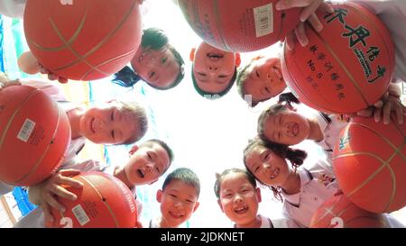 YANTAI, CHINA - 23. JUNI 2022 - Kinder posieren auf einem Spielplatz in einem experimentellen Kindergarten im Bezirk Penglai in Yantai, dem ostchinesischen Shandong Pro Stockfoto