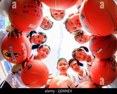 YANTAI, CHINA - 23. JUNI 2022 - Kinder posieren auf einem Spielplatz in einem experimentellen Kindergarten im Bezirk Penglai in Yantai, dem ostchinesischen Shandong Pro Stockfoto