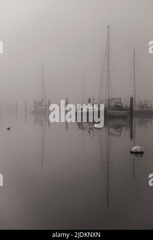 Boote in The Mist - River Yar, Yarmouth, Isle of Wight, UK Stockfoto