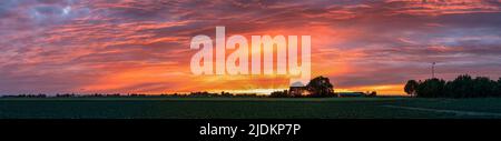 Panoramablick auf einen Sonnenuntergang mit atemberaubenden Farben über der niederländischen Landschaft Stockfoto