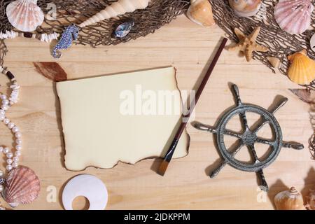 Leeres Papier mit verbrannten Kanten auf Holzhintergrund mit Meeresmuscheln und Fischernetz. Nautisches und Küstenthema Stockfoto