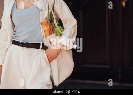 Nicht erkennbare stilvolle Frau hält Shopping Eco-Tasche mit Lebensmittel im Freien, Copy Space Stockfoto