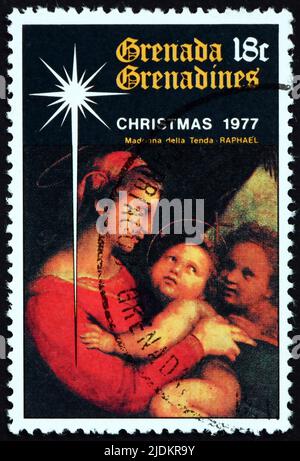 GRENADA UND GRENADINEN - UM 1977: Eine in Grenada gedruckte Marke zeigt Madonna mit Kind, Gemälde von Raphael, italienischer Maler, um 1977 Stockfoto