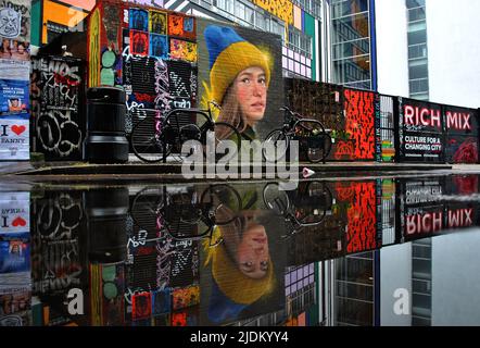 STREET-ART-PORTRÄT EINER UKRAINISCHEN FRAU, DIE EINEN HUT IN IHREN LÄNDERFARBEN TRÄGT, ZEIGT DIE UNTERSTÜTZUNG FÜR DIE UKRAINE NACH DER RUSSISCHEN INVASION IM FEBRUAR 22. Stockfoto