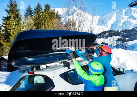 Junge Frau und Junge zusammen Ski in der Auto-Box, Rückansicht Stockfoto