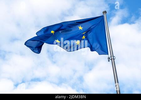 Flagge der EU winkt im harten Wind gegen den blauen Himmel Stockfoto