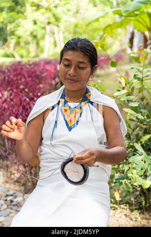 Indigene Frau aus der Sierra Nevada de Santa Marta sitzt und webt Stockfoto