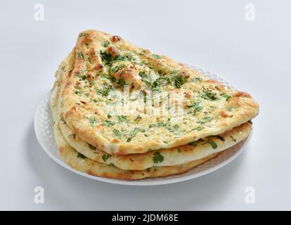 Knoblauch-Naan-Brot, traditionelles indisches Fladenbrot, in einem Tonofen gebacken. Köstlich, knusprig und würzig. Stockfoto