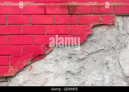 Rote Farbe auf Backstein gebrochen Mauerwerk Wand mit Zement weißen Beton beschädigt Fassade Hintergrundstruktur. Stockfoto