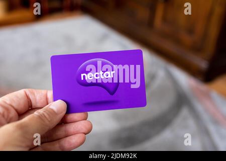 Weibliche Hand mit einer Sainsburys Nectar-Karte Stockfoto