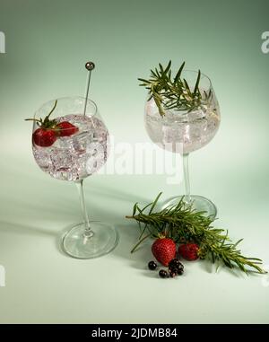 Gin und Tonic in Gläsern mit Erdbeer, blauem Hintergrund. Stockfoto
