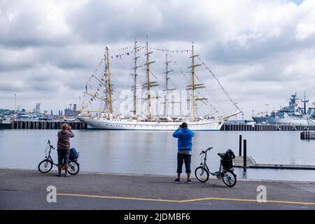 Kiel, Deutschland. 22.. Juni 2022. Ein Mann und eine Frau fotografieren das Segeltrainingsschiff „Gorch Fock“, das für die Kieler Woche dekoriert ist. Quelle: Frank Molter/dpa/Alamy Live News Stockfoto