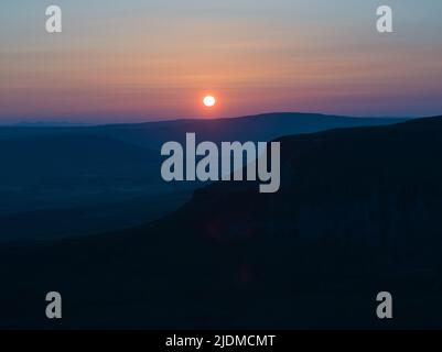 Sonnenuntergänge der unverwechselbaren Silhouette von Penyghent einer von drei Hügeln, die die Yorkshire 3 Peaks bilden Stockfoto