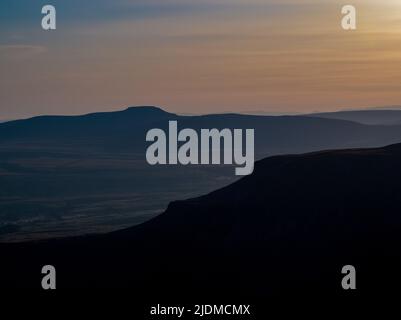 Sonnenuntergänge der unverwechselbaren Silhouette von Penyghent einer von drei Hügeln, die die Yorkshire 3 Peaks bilden Stockfoto