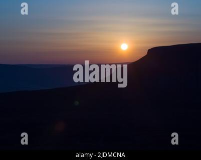 Sonnenuntergänge der unverwechselbaren Silhouette von Penyghent einer von drei Hügeln, die die Yorkshire 3 Peaks bilden Stockfoto