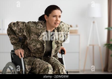 Konzept Der Querschnittsgelähmung. Soldatin, Die Versucht, Zu Hause Vom Rollstuhl Aufzustehen Stockfoto