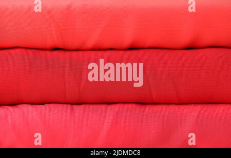 Rote Rollen aus gestricktem Stoff Textur Hintergrund Stockfoto