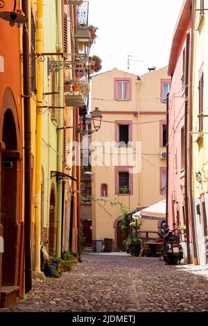 Leere schmale Straße mit bunten Häusern und vespa im Dorf os Bosa, Sardinien, Italien Stockfoto