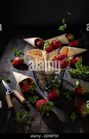 Frische Erdbeeren in Waffeln gesundes Dessert .Dunkler Hintergrund. Sommerjause. Stockfoto