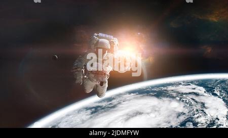 Astronaut im Weltraum auf einer niedrigen Umlaufbahn des Erdplaneten mit Sonnenlicht. Elemente dieses Bildes, die von der NASA eingerichtet wurden. Stockfoto