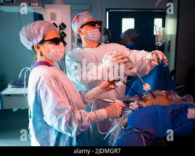 Moskau. Russland. 18. Oktober 2021. Chirurgen in 3D Gläsern operieren an einem Patienten. Laparoskopische minimalinvasive Chirurgie mit modernen 3D-Technologien. Stockfoto