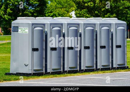Eine Reihe tragbarer Toiletten in einem Gemeinschaftspark. Stockfoto