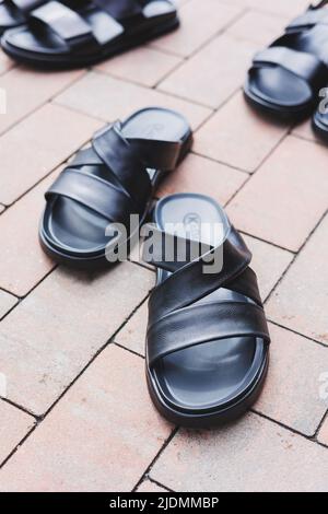 Schwarze Leder-Sandalen für Herren stehen auf einem isolierten Hintergrund. Sommerkollektion mit Herrenschuhen Stockfoto