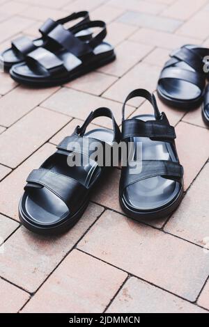 Schwarze Leder-Sandalen für Herren stehen auf einem isolierten Hintergrund. Sommerkollektion mit Herrenschuhen Stockfoto