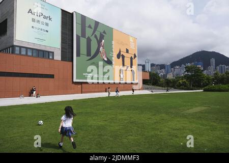 (220621) -- HONGKONG, 21. Juni 2022 (Xinhua) -- Ein Mädchen spielt auf dem Rasen neben dem Hong Kong Palace Museum im südchinesischen Hongkong, 17. Juni 2022. Das Hong Kong Palace Museum, das am 2. Juli für die Öffentlichkeit zugänglich sein soll, wird voraussichtlich mehr als 900 Schätze aus der Sammlung des Palastmuseums in Peking im Umlauf zeigen. (Xinhua/Wang Shen) Stockfoto