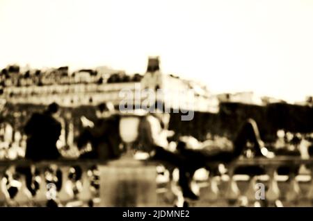 Verschwommenes Foto des luxemburgischen Gartens in Paris (Frankreich). Paare entspannen sich auf der Balustrade. Sepia. Stockfoto