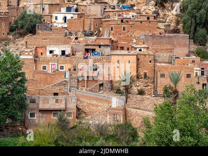 Dorf der Familie Berber mit Mauern aus Steinen und Lehm und Türen, Dächern und Zäunen aus Ästen. Atlasgebirge und blauer Himmel im Bac Stockfoto