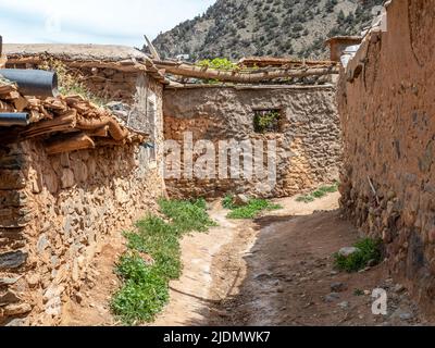 Dorf der Familie Berber mit Mauern aus Steinen und Lehm und Türen, Dächern und Zäunen aus Ästen. Atlasgebirge und blauer Himmel im Bac Stockfoto