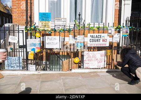 Plakate und Plakate gegen den russischen Präsidenten Wladimir Putin und seine Invasion in der Ukraine sind gegenüber der russischen Botschaft in London zu sehen. Stockfoto