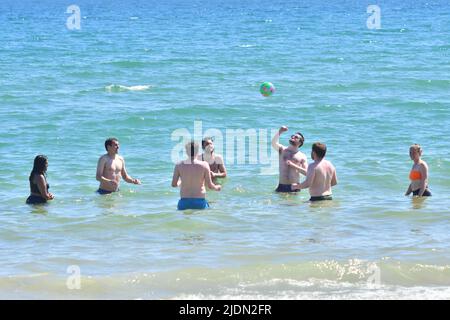 Bournemouth, Dorset, Großbritannien, 22.. Juni 2022, Wetter. Heißer Nachmittag bei herrlicher Sommersonne. Gemischte junge Menschen spielen Ball im Meer. Kredit: Paul Biggins/Alamy Live Nachrichten Stockfoto